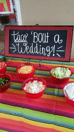 a table topped with bowls of food and a sign that says taco bouta wedding