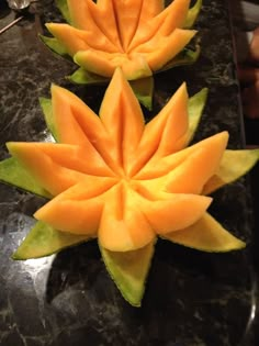 two pieces of fruit are arranged in the shape of flowers on a marble countertop