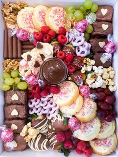 a white box filled with lots of different types of cookies and desserts on top of each other