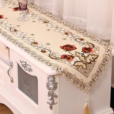 a kitchen counter with an embroidered tablecloth on it