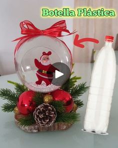 a glass snow globe sitting on top of a table next to a bottle of water