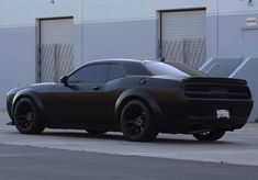 a black sports car parked in front of a building