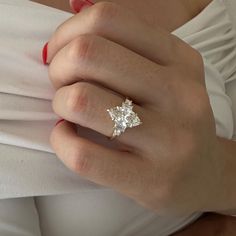 a woman's hand with a ring on it and a star shaped diamond in the middle