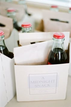 several bottles of soda are sitting in small boxes