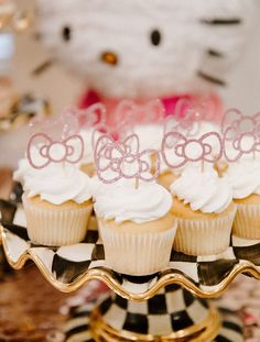 there are cupcakes on the cake stand with hello kitty toppers in them