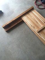 a piece of wood sitting on top of a floor next to a pair of scissors