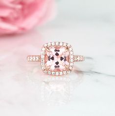 Beautiful Cushion Halo Morganite Ring ►Base metal: sterling silver (925) ►Plating: 14K Rose Gold ►Accented With Simulated Diamonds (CZ) Center Stone: Morganite Color: Peachy-Pink Shape: Cushion Measurements: 8.0 x 8.0 mm Carat Weight: 2.4 ct. (approx.) Gemstone creation: Lab-Created ►Please be aware that plated jewelry can wear off over time, if this is a concern we would suggest going with the sterling silver or solid gold jewelry option. ►Sterling silver ring version can be purchased here: htt Classic Morganite Cushion Cut Rings, Classic Morganite Diamond Ring For Wedding, Classic Morganite Diamond Wedding Ring, Rose Gold Halo Setting Ring As A Gift, Rose Gold Halo Setting Wedding Ring As Gift, Rose Gold Halo Setting Wedding Gift, Pink Diamond Ring For Anniversary, Round Cut, Classic Pink Halo Ring With Gemstone, Pink Round Cut Diamond Ring For Anniversary