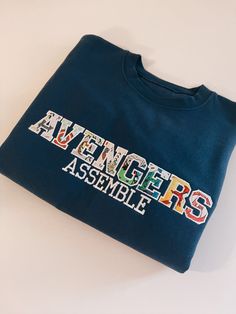 Assemble Embroidered Sweatshirt – HaizCo Cheap Fandom Crew Neck Tops, Marvel Hoodies For Women, Matching Hoodies Marvel, Marvel Crewneck Sweatshirt, Cheap Embroidered Fan Merchandise Tops, Marvel Pullover, Marvel Fashion, Marvel Clothes, Diy Vetement