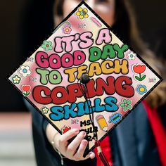 a woman wearing a graduation cap that says it's a good day to teach coping skills