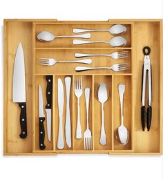 a wooden tray with utensils and spoons in it