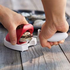 a person is using a device to cut up a piece of food on a wooden table