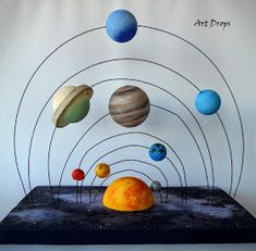 an art project with different planets in the sky and on top of a black surface