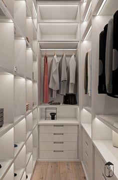 a walk in closet with white shelving and drawers