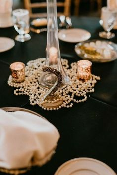 the table is set with pearls and candles