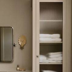 the bathroom is clean and ready to be used as a storage area for folded towels