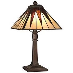 a lamp that is sitting on top of a wooden stand with a glass shade over it