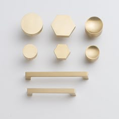 various brass knobs and pulls on a white surface, including one in the middle