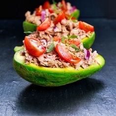 two halves of avocado with tuna, tomatoes and lettuce on top