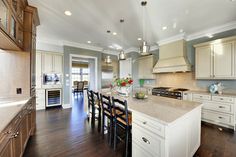 a large kitchen with an island, stove and dining room table in the center area