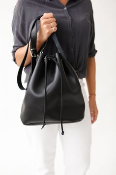 Of great quality, this leather women's handbag is a season's statement piece. It is handmade with care to the detail and to last for years. Its modern, minimal design will never go out of fashion.  The wide variety of colors we offer, make this shoulder bucket bag match any day or night look. Its unstructured shape provides  plenty of  room for your personal items.  The metallic backles offer durability, while its drawstring secures your stuff. The strap is long and adjustable.  Made of premium genuine leather, all our bags are handcrafted in Greece. WOULD MAKE A UNIQUE GIFT  2 SIZES  4 LEATHER COLOURS: NATURAL / BLACK/ NUBUCK BROWN / GOLD Womens Bag Bucket shape Adjustable Shoulder Strap Drawstring at the top Durable, Metalic Buckles Without lining Premium Full Grain Leather Handmade in G Cheap Bucket Bag With Chain Strap, Gift Bucket Satchel With Dust Bag, Black Satchel With Dust Bag As Gift, Modern Bucket Shoulder Bag For Gift, Modern Bucket Bag As Gift, Modern Bucket Bag For Gift, Leather Hobo Bag With Dust Bag For Everyday Use, Modern Bucket Bag For Gifts, Modern Leather Clutch Bucket Bag