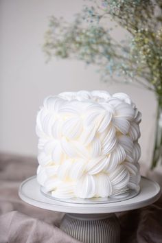 a white frosted cake sitting on top of a plate