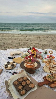 there are many desserts on the table at the beach