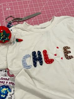 a t - shirt with the word chi on it next to scissors and other crafting supplies