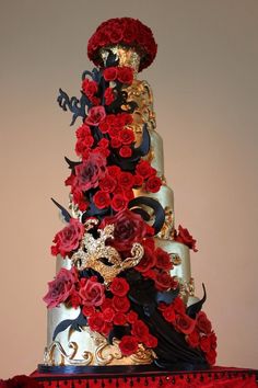 a three tiered cake decorated with red flowers