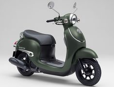 a green scooter parked on top of a white floor