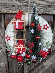 a christmas wreath hanging on the side of a wooden door next to a small tree