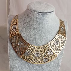 Elevate your style to the grandeur of Cleopatra herself with our Cleopatra Design Gold Maximalist Geometric Bib Statement Necklace. he necklace boasts an intricate maximalist design that captures the essence of opulence. This statement piece is inspired by Cleopatra's iconic jewelry, where every piece she wore symbolized power, wealth, and beauty. Elegant Gold Jewelry With Artistic Design, Elegant Artistic Gold Jewelry, Metal Choker Bib Necklace In Costume Jewelry Style, Metal Choker Bib Necklaces For Costume Jewelry, Modern Metal Jewelry With Artistic Design, Elegant Gold Choker Bib Necklace, Metal Chain Bib Necklace Gift, Metal Chain Bib Necklace For Gift, Metal Chain Bib Necklaces As Gift