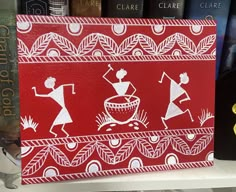 a red and white painting on the side of a shelf