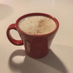 a red cup filled with liquid sitting on top of a table