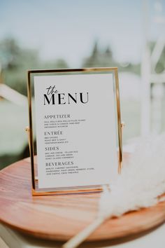 a table with a sign that says bar menu on it and some feathers in the foreground