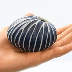 a hand holding a blue and white ceramic object