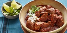 a bowl filled with meat and onions next to a small bowl of cilantro