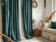 a living room filled with furniture and green drapes on the windowsill, next to a wicker basket