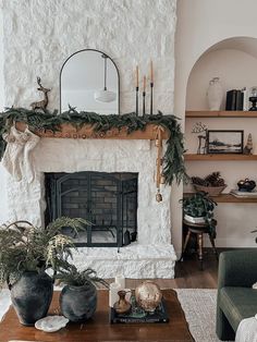 a living room filled with furniture and a fire place covered in greenery next to a fireplace