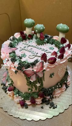 a birthday cake decorated with flowers and butterflies