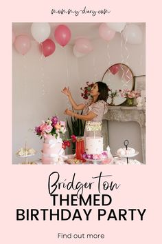 a woman standing in front of a birthday cake with pink balloons and flowers on it