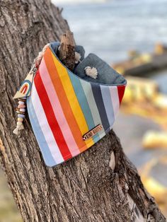 a multicolored hat hanging on the side of a tree