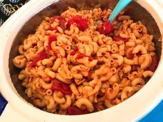 a bowl filled with macaroni and cheese on top of a blue table cloth