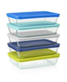 four glass containers stacked on top of each other with lids in different colors and sizes