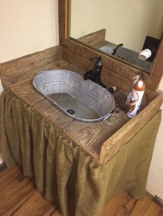 a bathroom sink with a metal tub and mirror