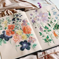 an open book with flowers painted on it