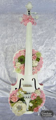 a violin decorated with flowers and ribbons