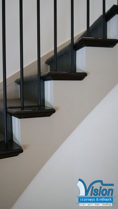 a set of stairs with black handrails on each side and white walls in the background