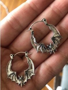 Elevate your style with the perfect blend of elegance and edge with our Flying Bat Hoop Earrings. These chic and charming earrings feature a captivating flying bat design, adding a touch of spooky flair to any outfit. Crafted in a sleek silver finish, they are approximately 1" in diameter, making them an ideal statement piece without being overpowering. The unique and secure bar-and-clasp closure ensures these earrings are suitable for both gauged and non-gauged piercings, offering a comfortable Vampire Bites, Flying Bat, Bat Jewelry, Bat Design, Spooky Style, Backpack Lunch Bag, Candle Wax Melts, Garden Wall Art, Jewelry Pins