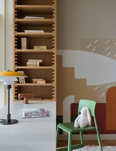 a room with a chair, bookshelf and stuffed animal