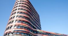 a very tall building with many windows on it's side and a sky background